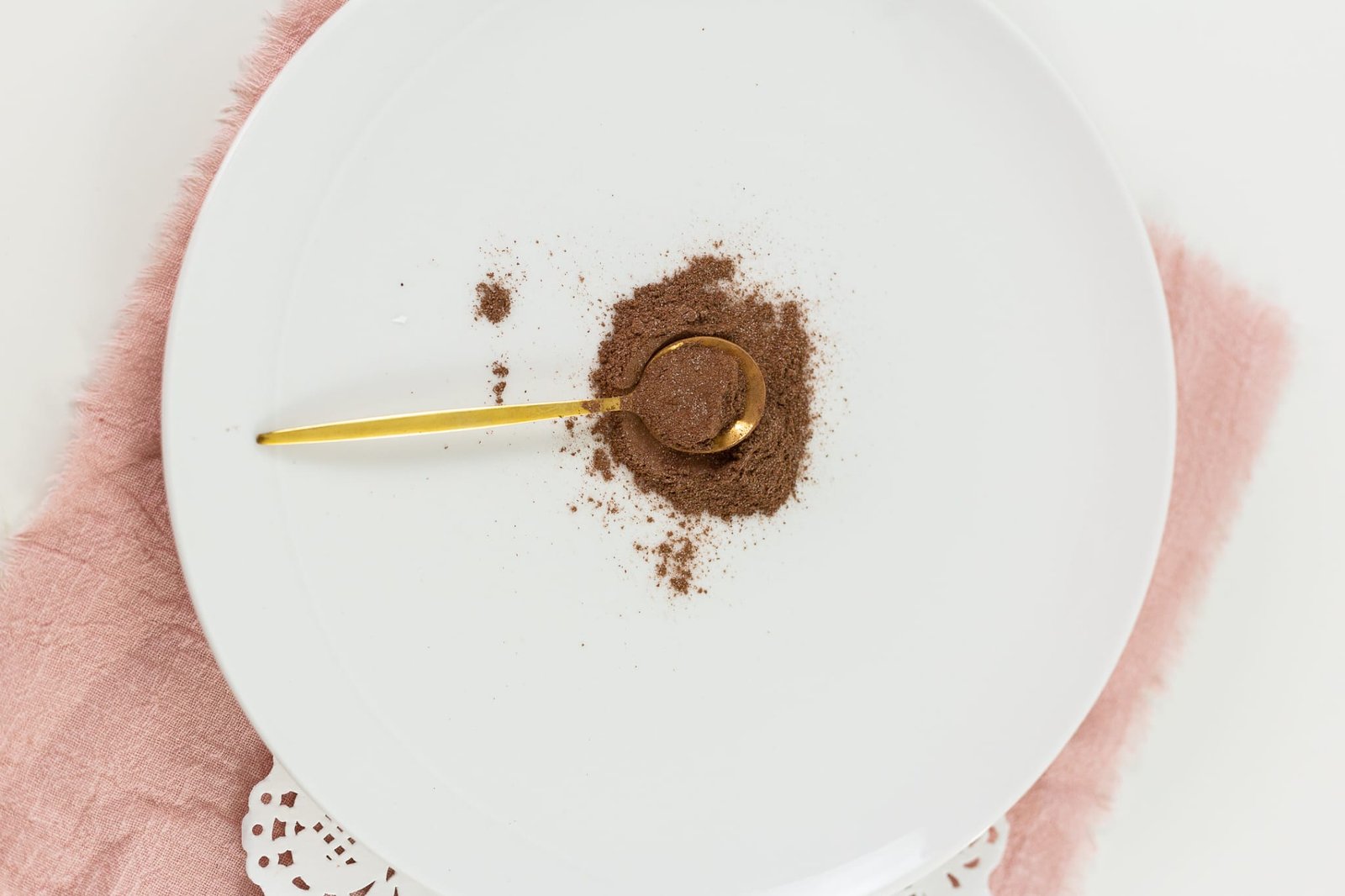 Cocoa powder on a plate with a golden spoon