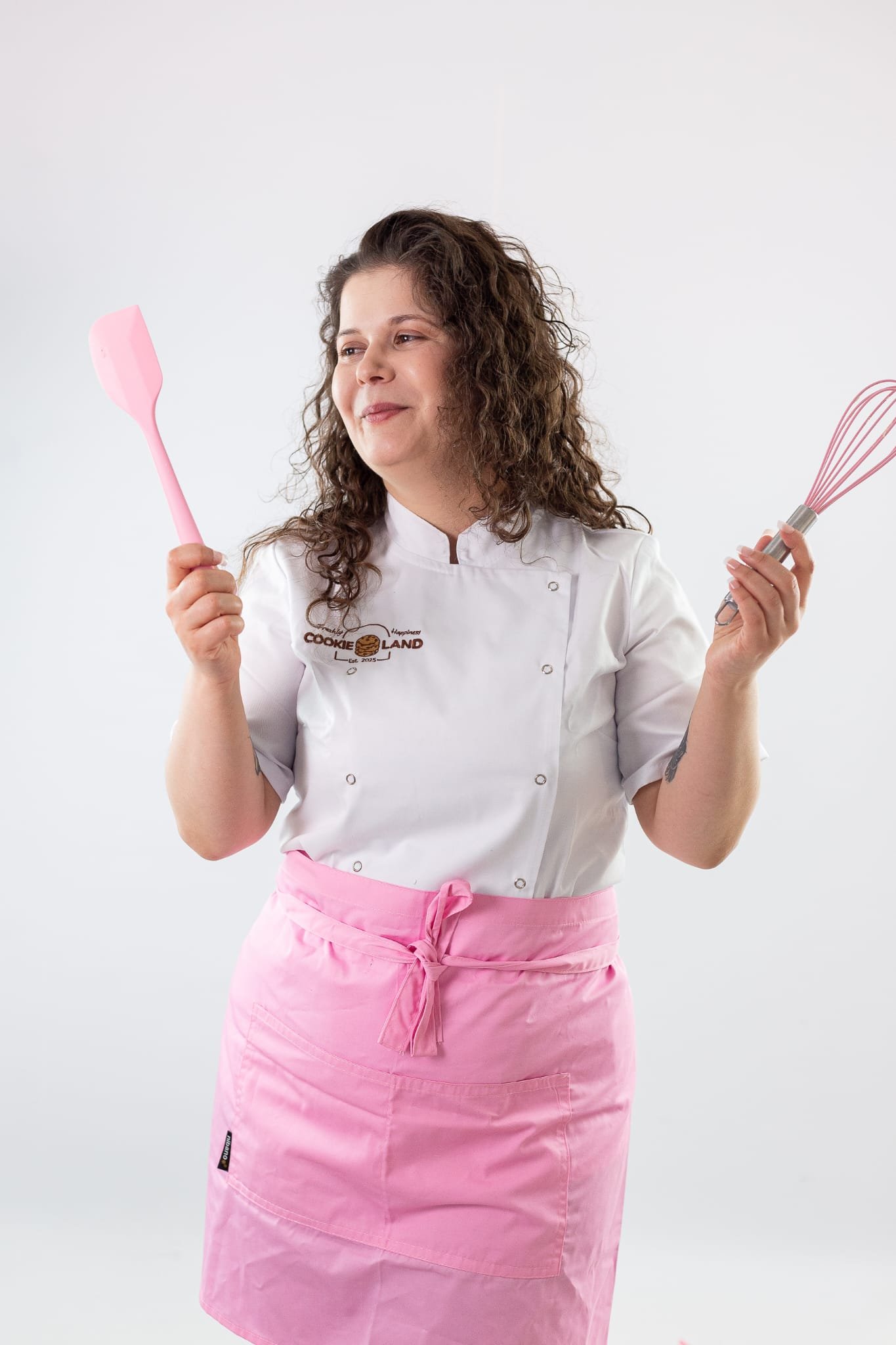 Cookieland founder smiling with a whisk and spatula