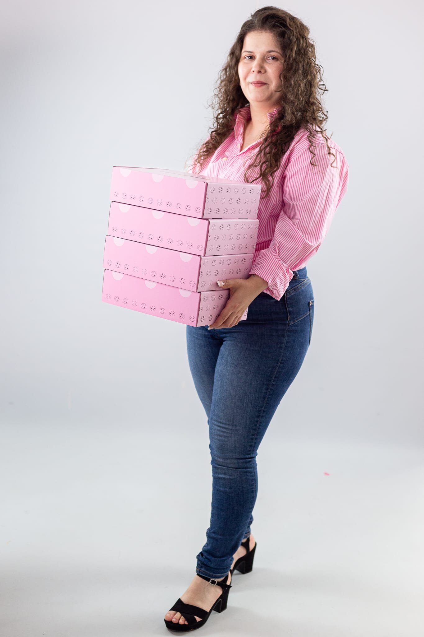 Cookieland founder holding a stack of pink Cookieland boxes