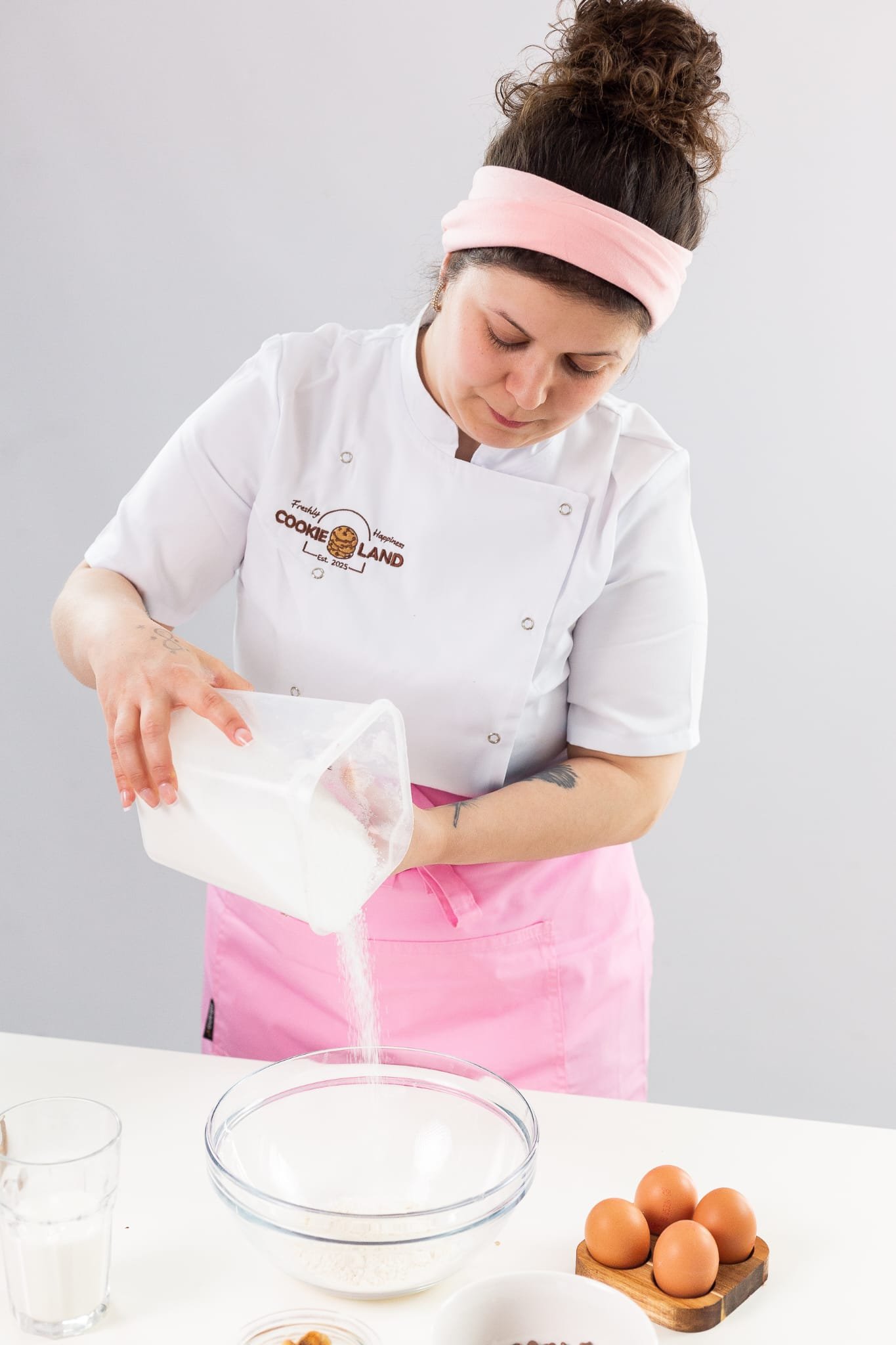 Cookieland founder pouring flour into a bowl while baking