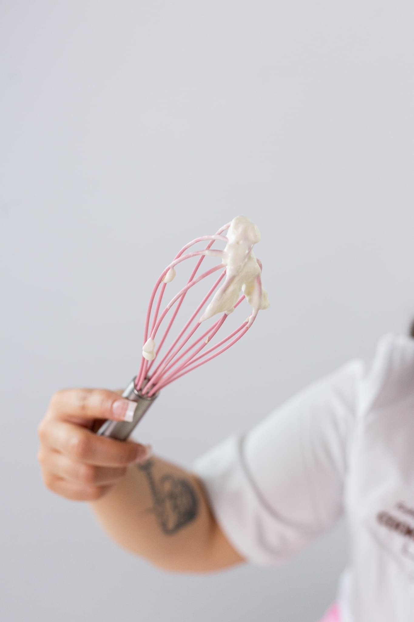 Pink whisk with whipped cream